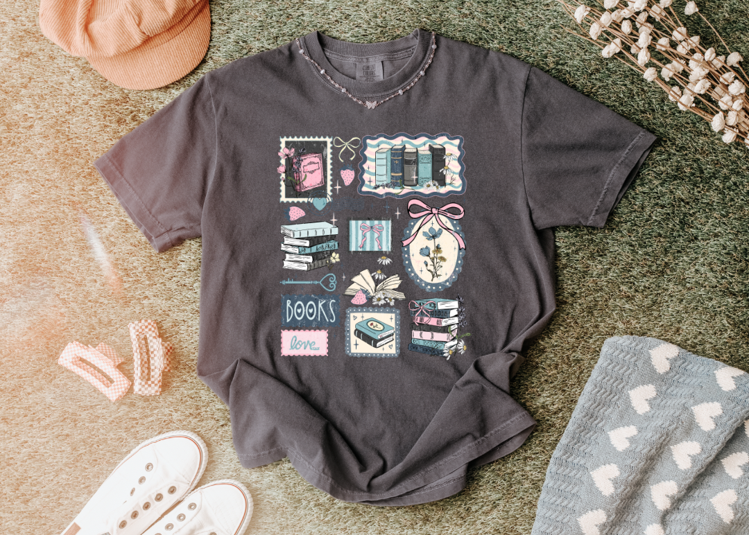 Gray t-shirt with graphic design on a textured surface with accessories.