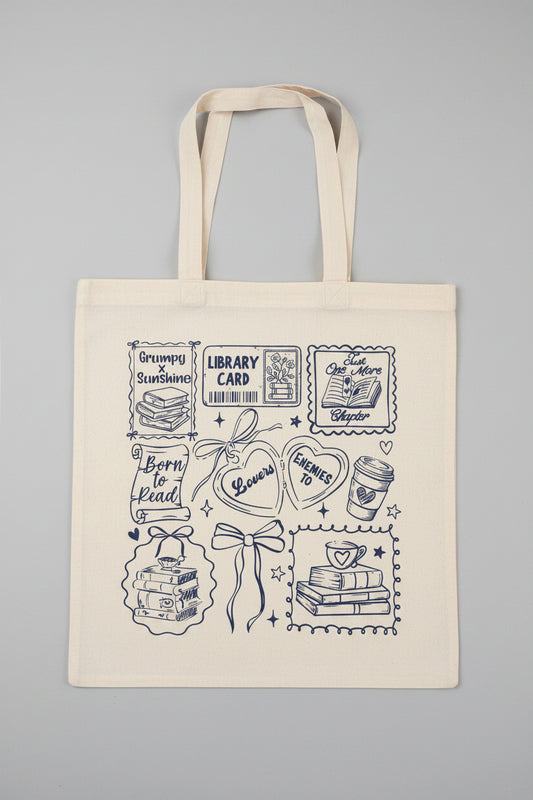 Tote bag with black line art designs on a wooden surface