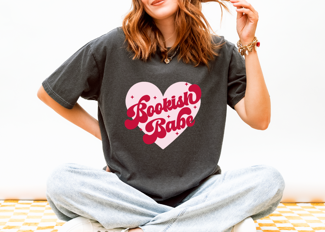 Person wearing a gray t-shirt with 'Bookish Babe' design sitting on a white background