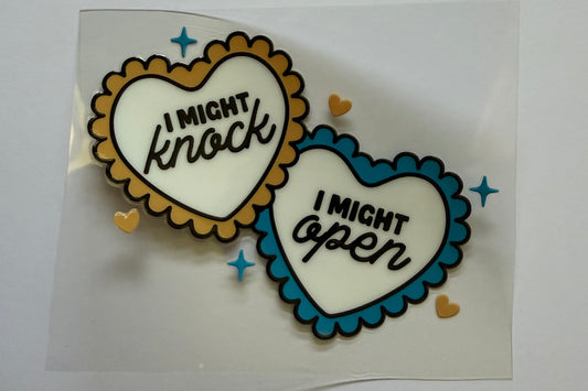 Two heart-shaped patches with text on a clear background