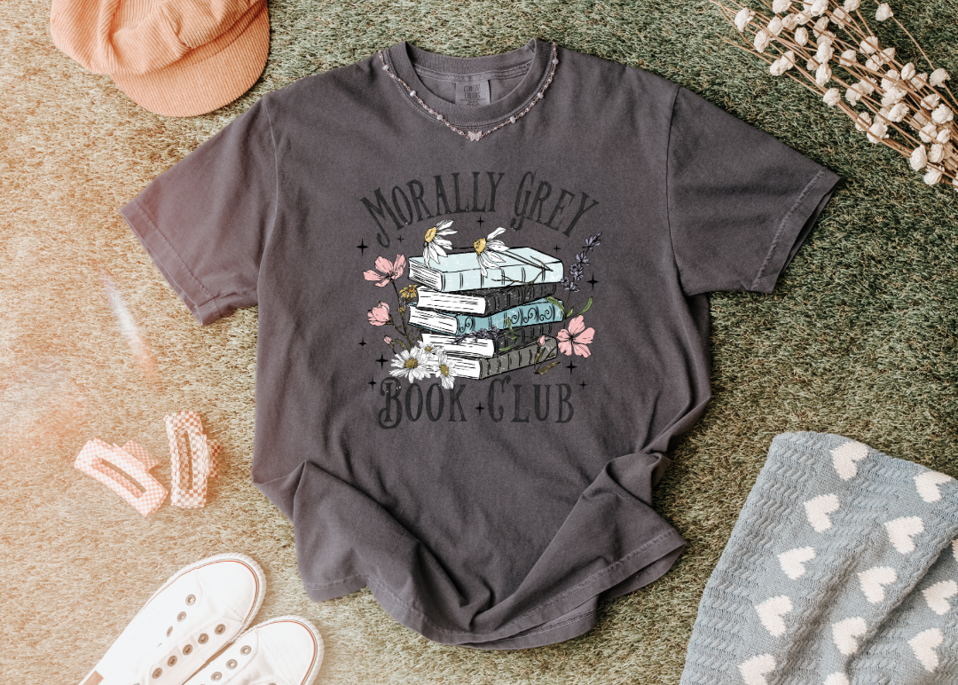 Gray t-shirt with 'Morally Grey Book Club' design on a textured surface.