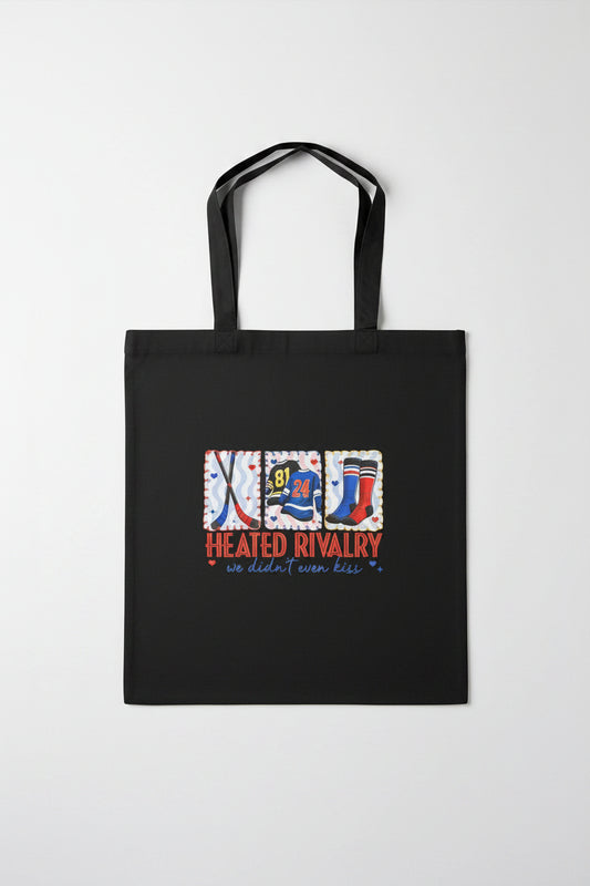 Black tote bag with sports-themed design on a wooden surface